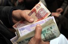 دست‌های یک مرد در حال نگه داشتن اسکناس‌های افغانی