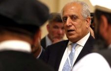 خلیل‌زاد با کت و شلوار تیره و شال گردن آبی در یک جلسه رسمی