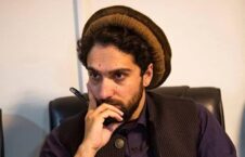 مردی با کلاه سنتی و ریش در حال تفکر با قلم در دست