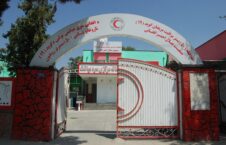 Entrance of the Afghan Red Crescent Hospital with a white arch and writings in Dari and Pashto