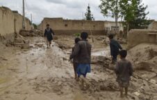Four children and one adult in a destroyed alley after the flood