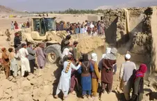 Residents beside the destroyed well and bulldozer in a rural area