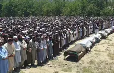 Group funeral prayer over several coffins in an outdoor space